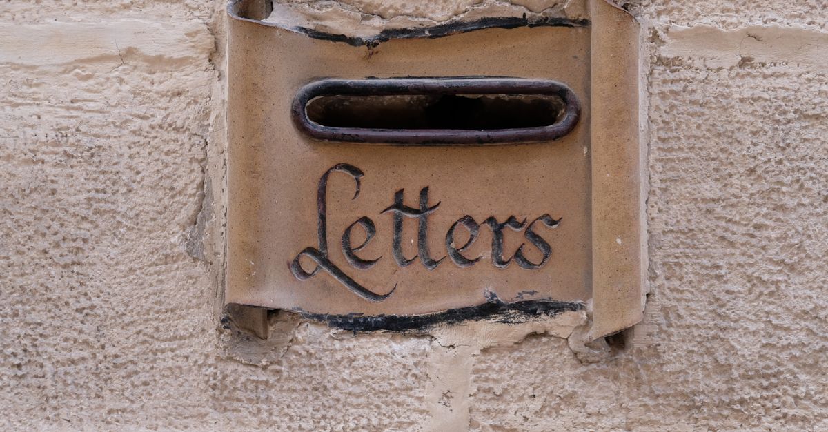 Elegant vintage letterbox embedded in a stone wall, captured in Malta.